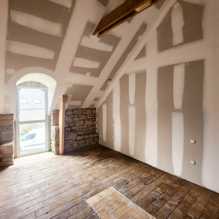 Chantier de rénovation intérieure, pièce mansardée avec plancher bois ancien