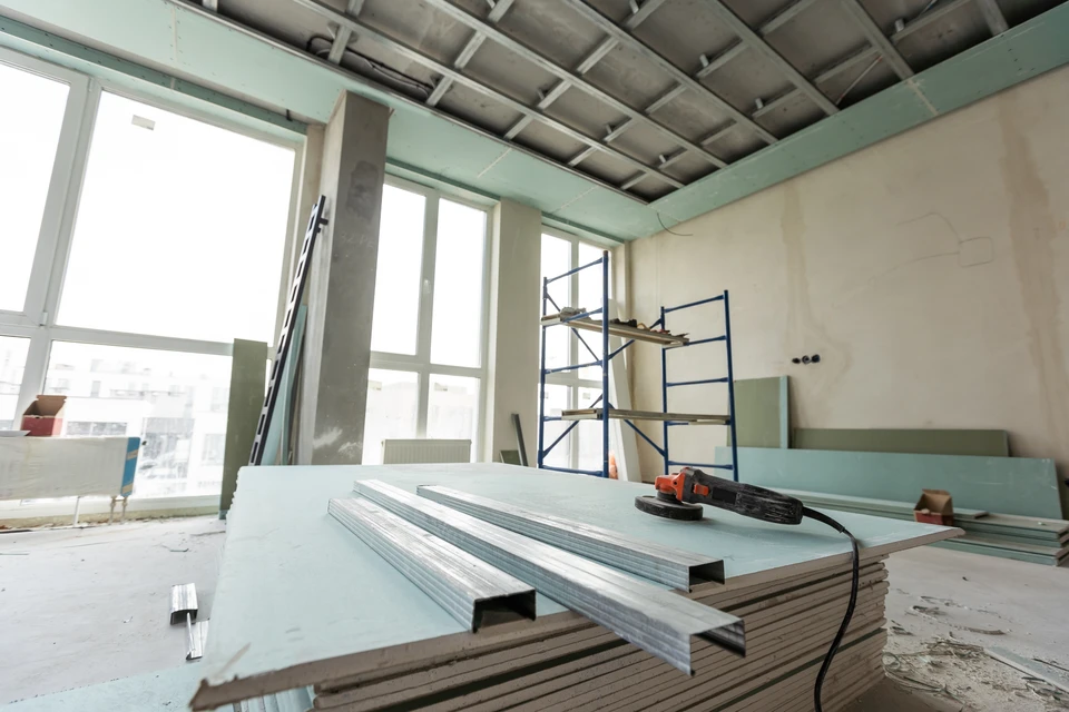 Chantier de rénovation intérieur avec ouvriers installant cloisons sèches