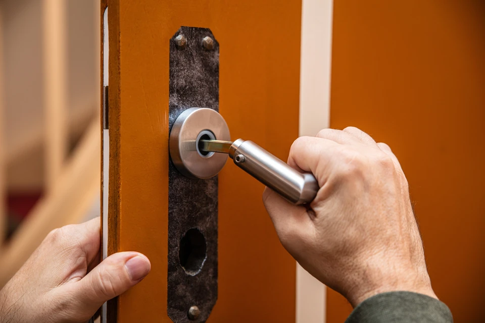 Intérieur moderne avec porte en bois naturel ouverte donnant sur un couloir sombre