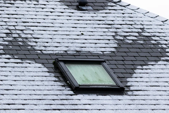 Portrait vertical d'un toit en ardoise gelé avec une fenêtre de lucarne qui est également gelée en hiver