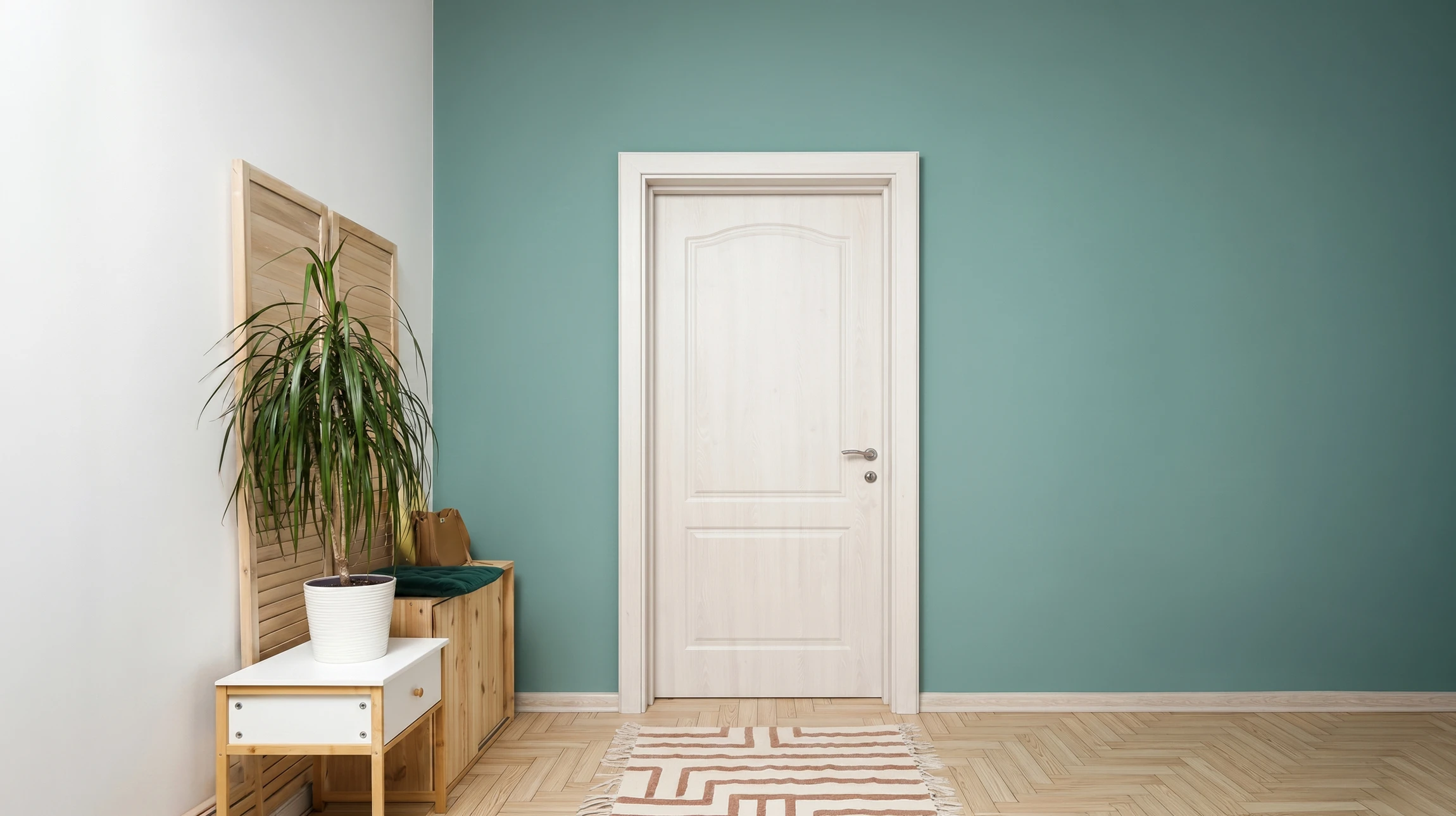 Un homme en chemise à carreaux installe ou répare une porte en bois dans un intérieur résidentiel
