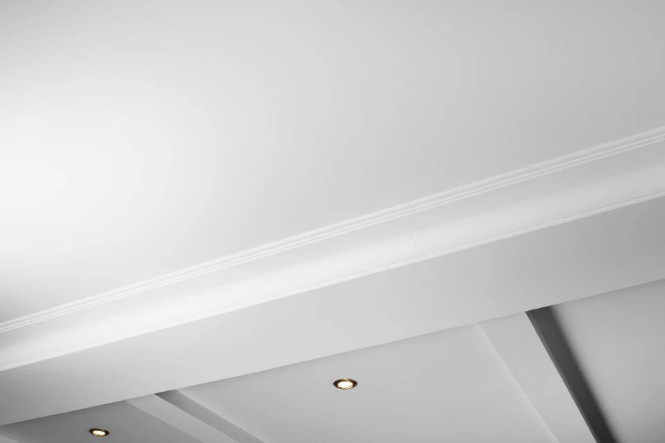 Intérieur résidentiel avec plafond à caissons en staff blanc décoré de moulures classiques