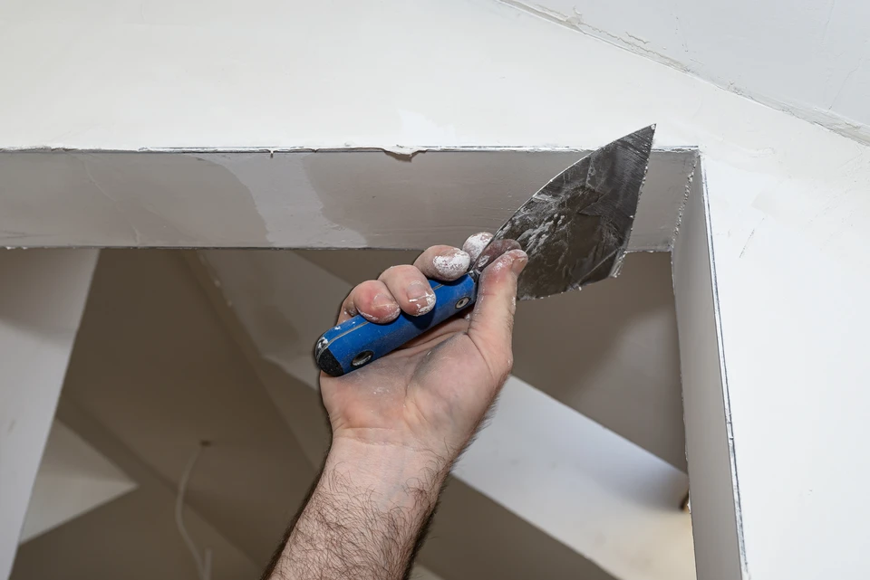 Ouvrier en bâtiment installant des cloisons sèches dans un intérieur en rénovation
